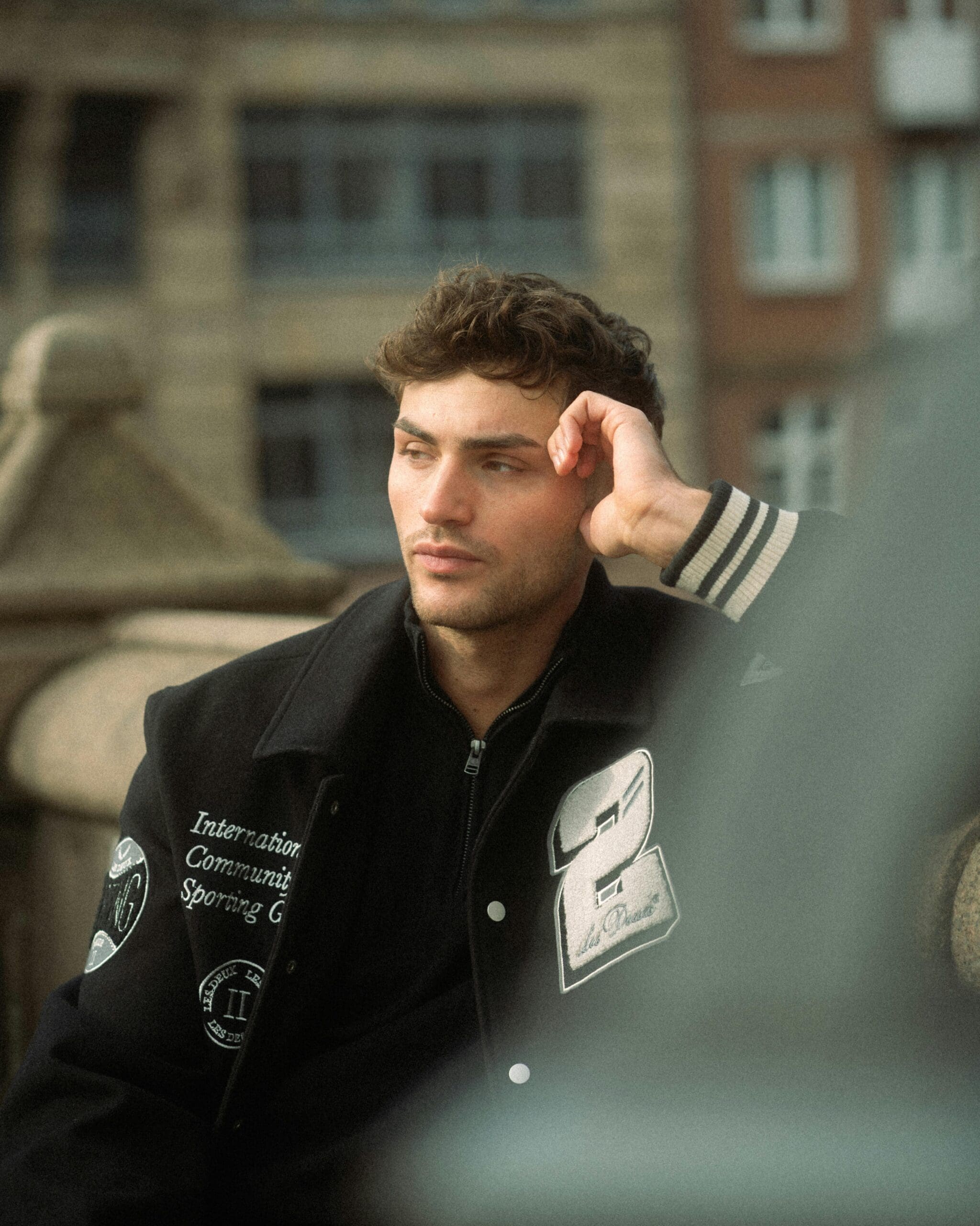 Man alone in a city looking into the distance to represent the male loneliness epidemic.