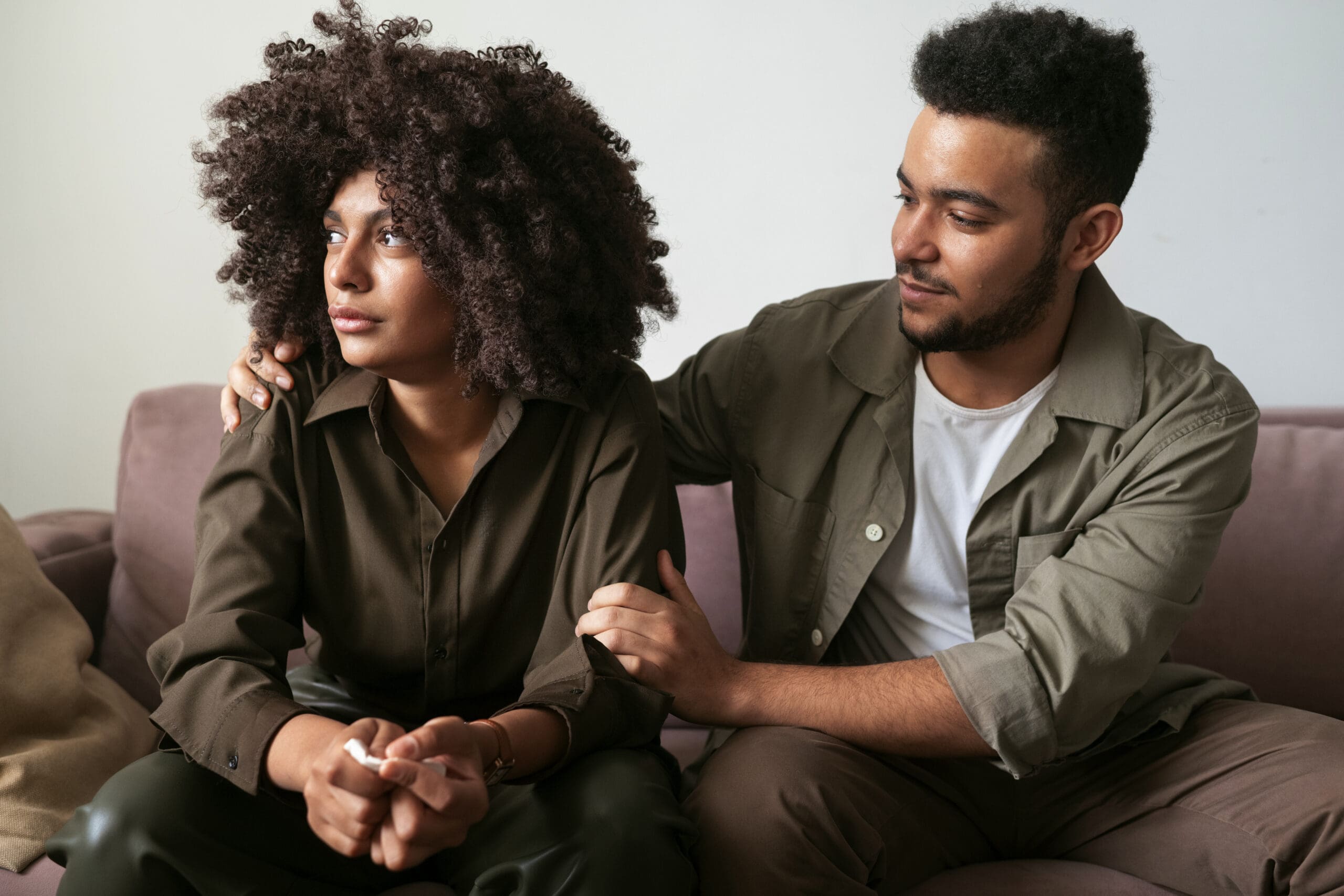 Young couple sitting while man thinks about how to help someone with depression