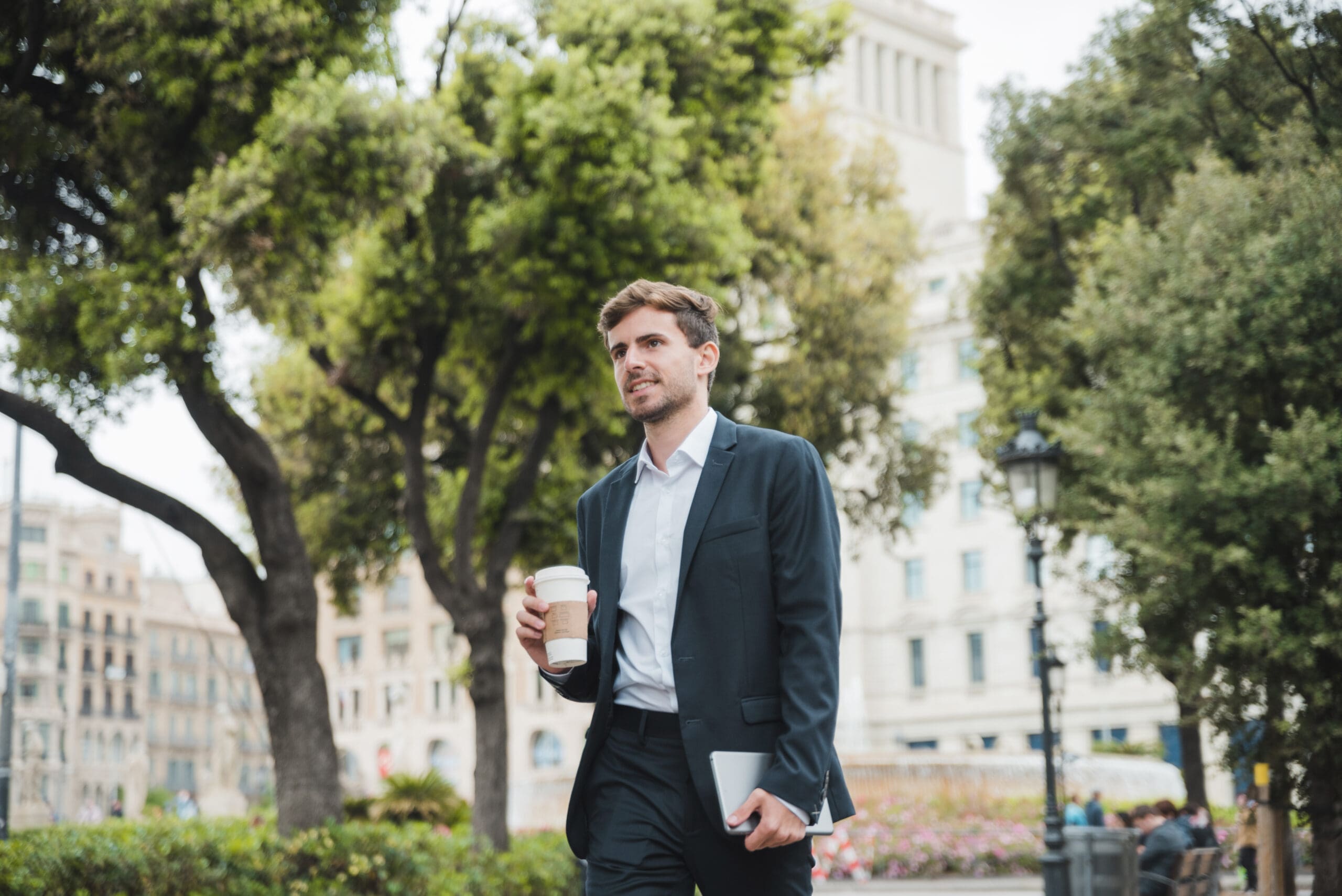 Young businessman in his first job after college walking with coffee cup