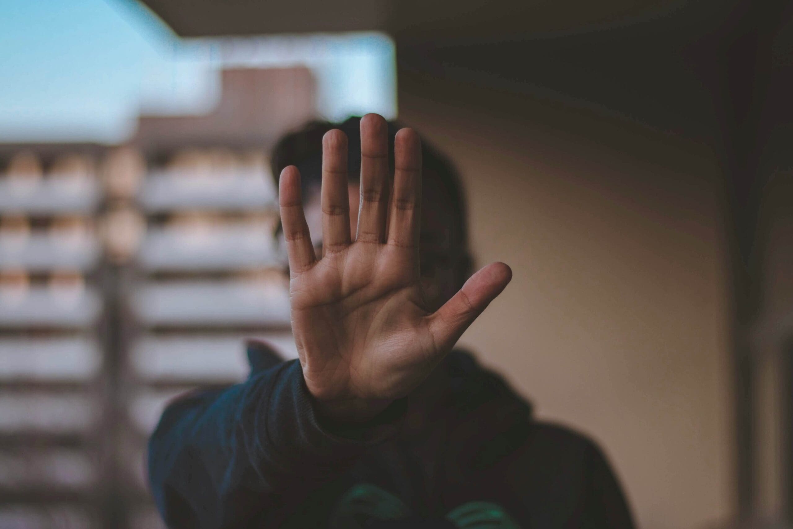 Man holding up hand representing when perfectionism becomes self-sabotage